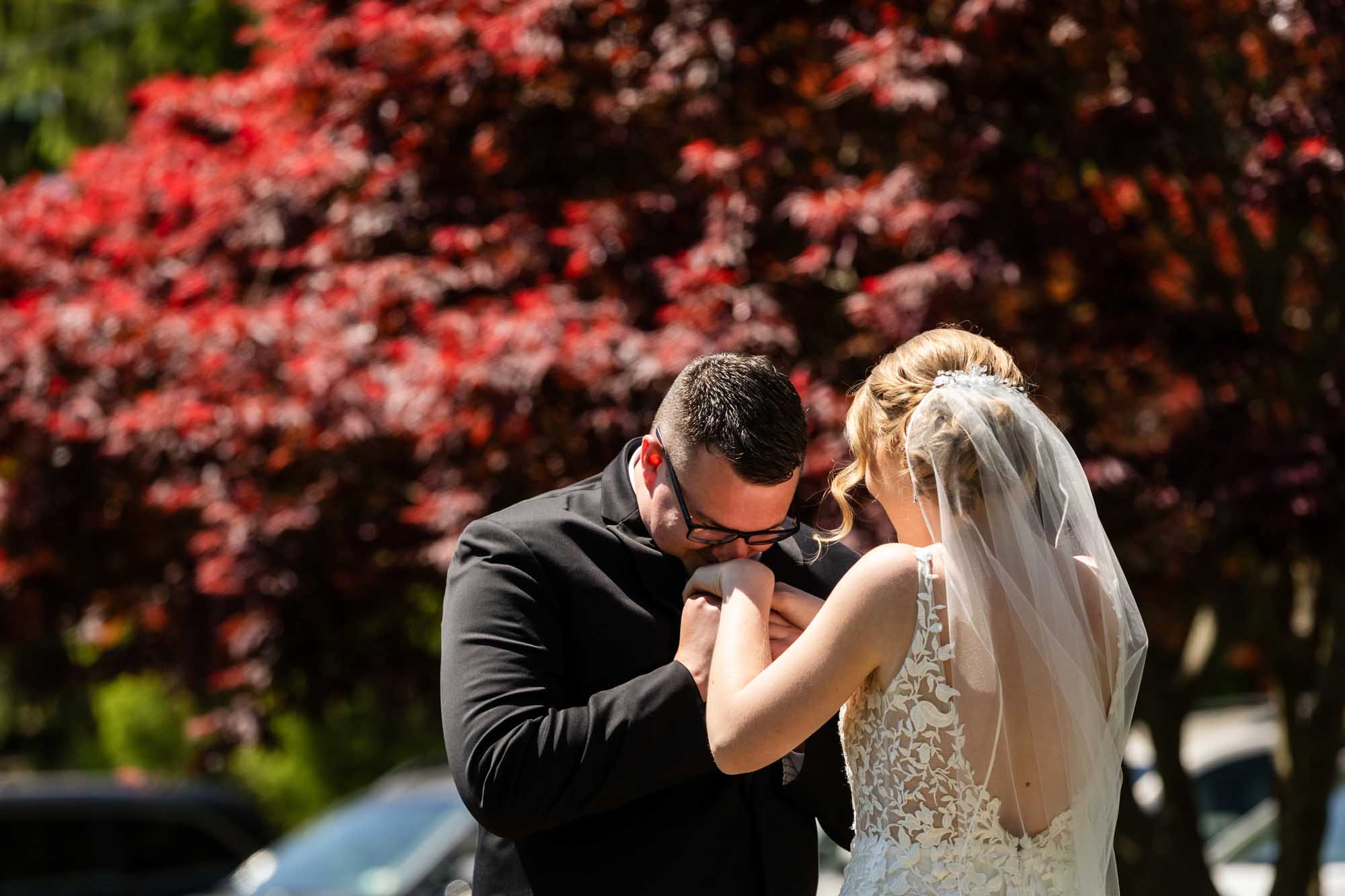 groom kisses bride's hand when he sees her at their first look at pinehall at eisler farms